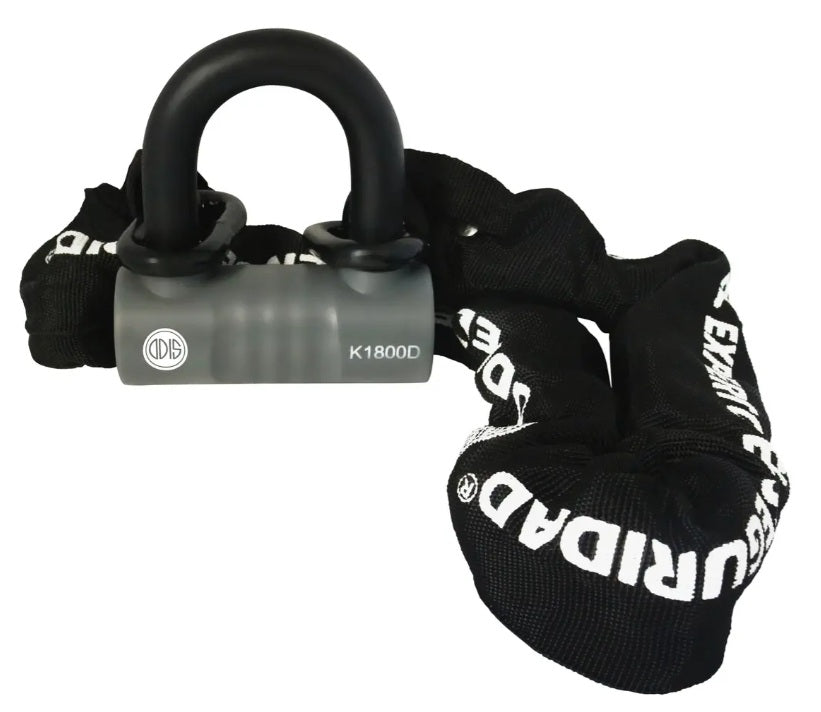 Kit de seguridad Odis Bike K1800D que muestra el candado tipo U-Lock de acero resistente con cuerpo gris y la cadena protectora extendida hacia el fondo sobre fondo blanco. Fotografía de producto para Proyecto Madera Chile.