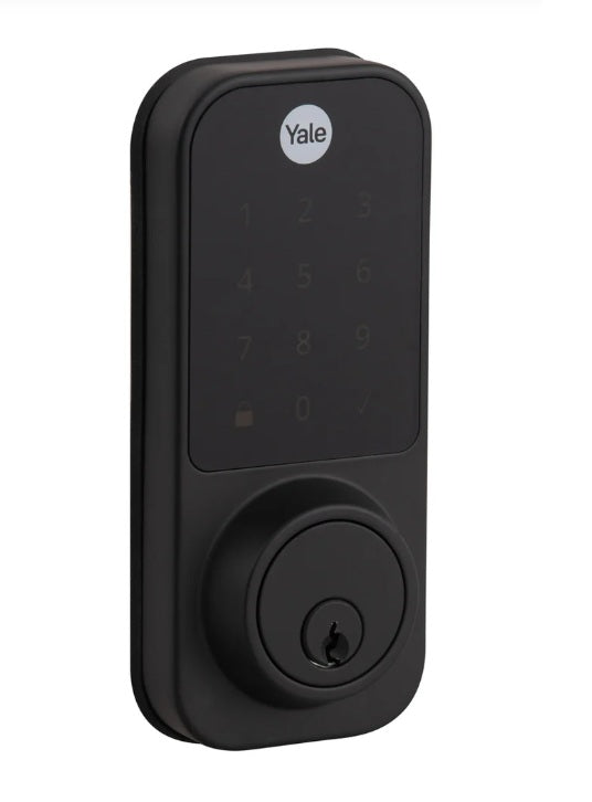 "Vista en perspectiva del panel exterior del cerrojo digital Yale YDD120 negro con pantalla táctil reposada y entrada para llave de seguridad."