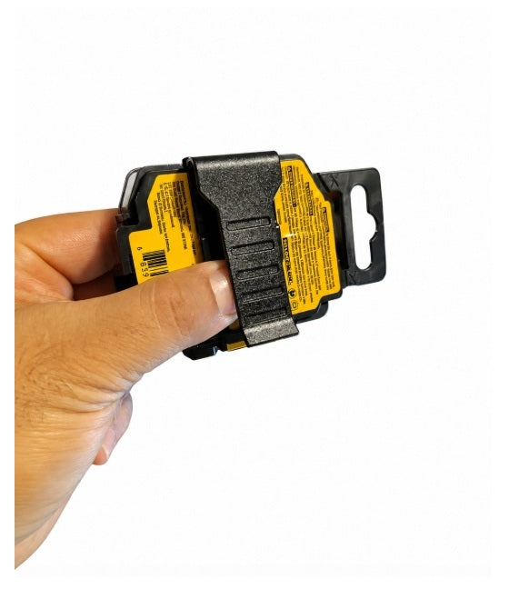 Mano sujetando el reverso del estuche de puntas DeWalt, mostrando el clip de cinturón integrado y etiquetas de código de barras.
